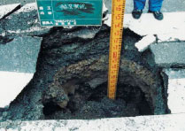 道路の陥没した深さを測っている様子